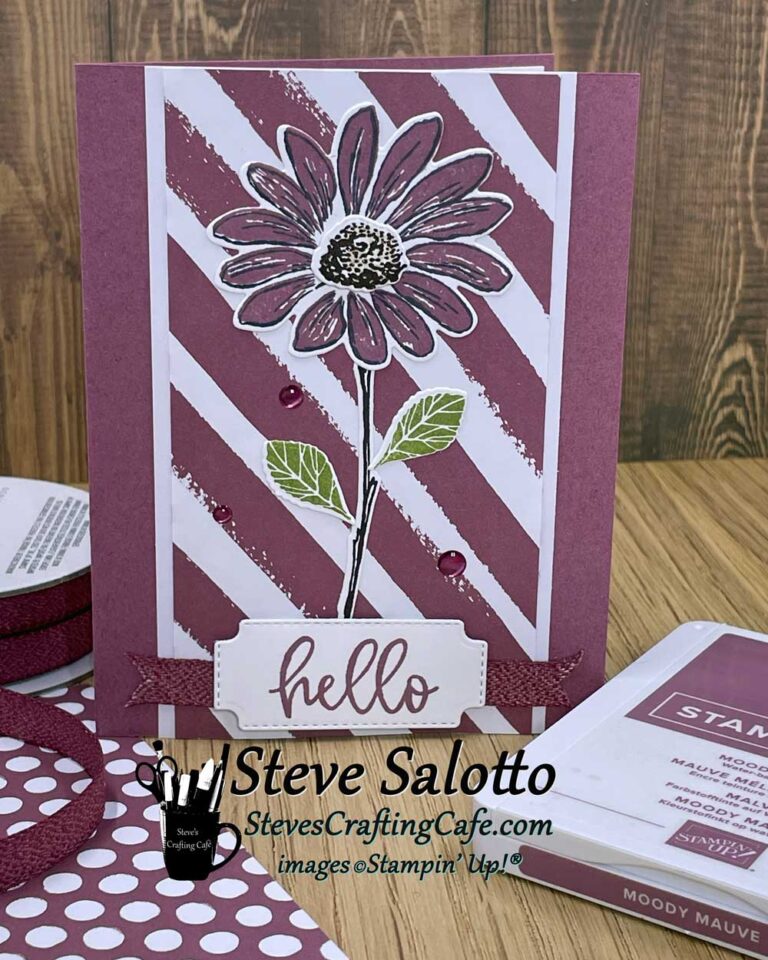 A greeting card with a mauve daisy on it that says "hello"