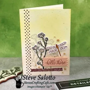A pale pink and yellow greeting card with a pink dogwood flower stamped on it and the sentiment "hello there."