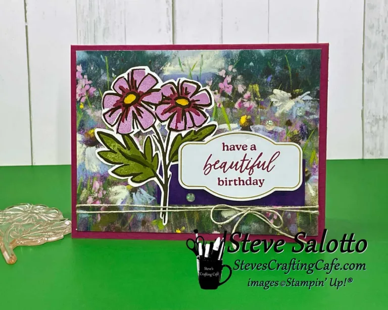 A greeting card with a scenic field and stamped flowers over it. A sentiment reads, "Have a Beautiful Birthday."