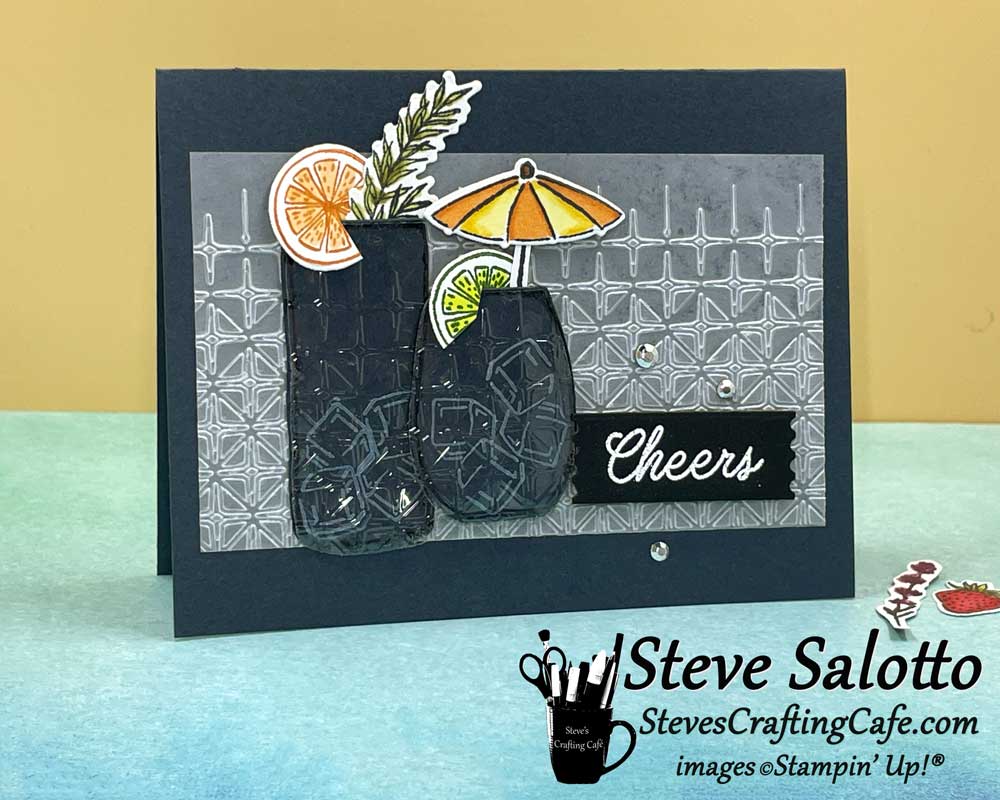 A dark teal card with two cocktails on it and the sentiment, "Cheers"