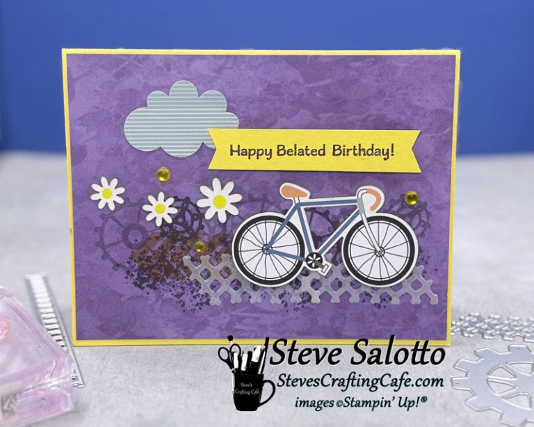 A purple card with a bicycle on it, flowers, gears, and the sentiment "Happy Belated Birthday."