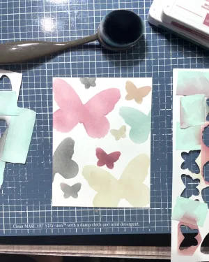 A piece of card stock with silhouettes of butterflies.
