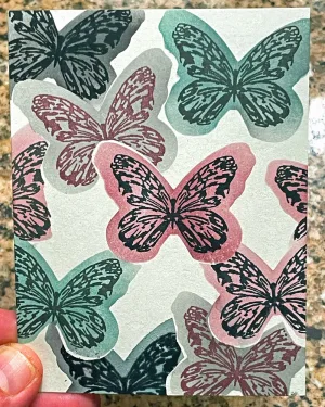 Overlapping stamped butterflies on a card base.