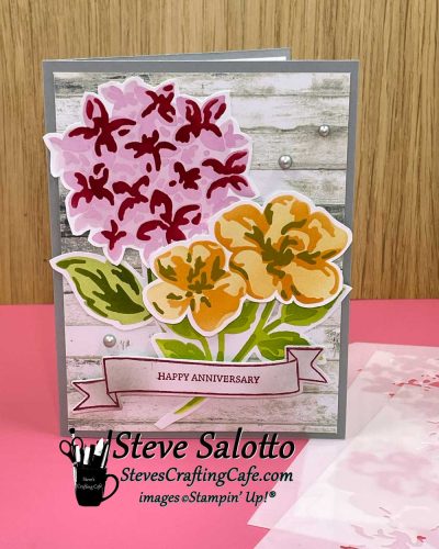 A greeting card with pink and orange flowers on it and the sentiment, "Happy Anniversary."